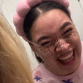 A woman laughing as she sees the effects of her henna freckles