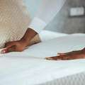 A woman making the bed inside a room
