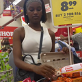 A woman takes two eggs from a Shoprite store