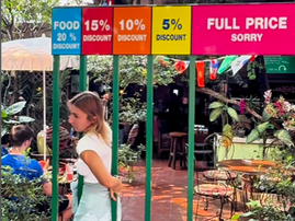 A woman tries passing through gated bars to earn a discount at restaurant