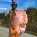 A woman wearing a sari standing with her skateboard