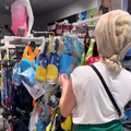 A woman wearing rollers in her hair shopping at a clothing store
