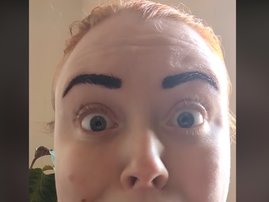 A woman with a shocked look on her face and tinted eyebrows