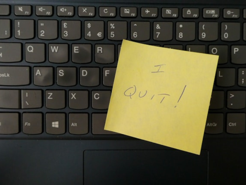 A yellow notepad on a keyboard that reads I Quit