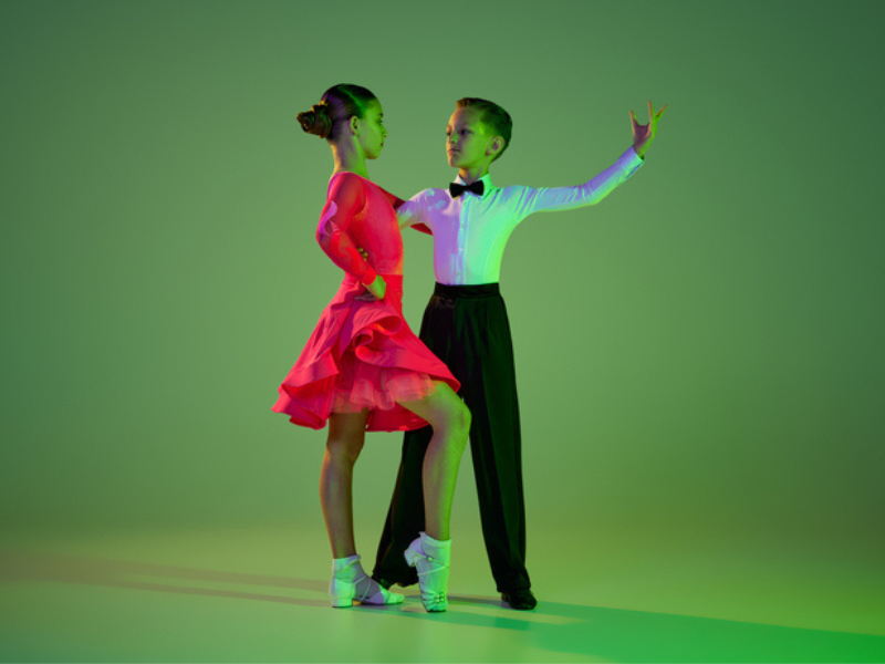 A young girl and boy dance to the rumba tango