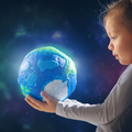 A young girl looks at the world globe in her hands