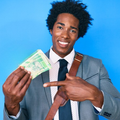 African man wearing a business suit holds up South African Rand