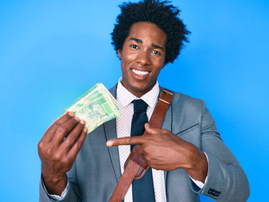 African man wearing a business suit holds up South African Rand