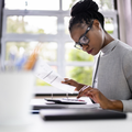 An African woman working at her desk with a calculator