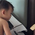 An infant talking on the phone inside a hotel room