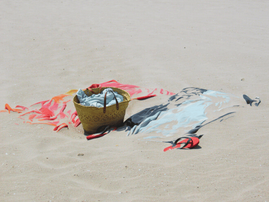 Beach towel and other belongings messed with beach sand at the beach