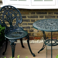 Black steel table with chair outside a house