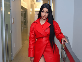 Cardi B wearing a long red leather coat