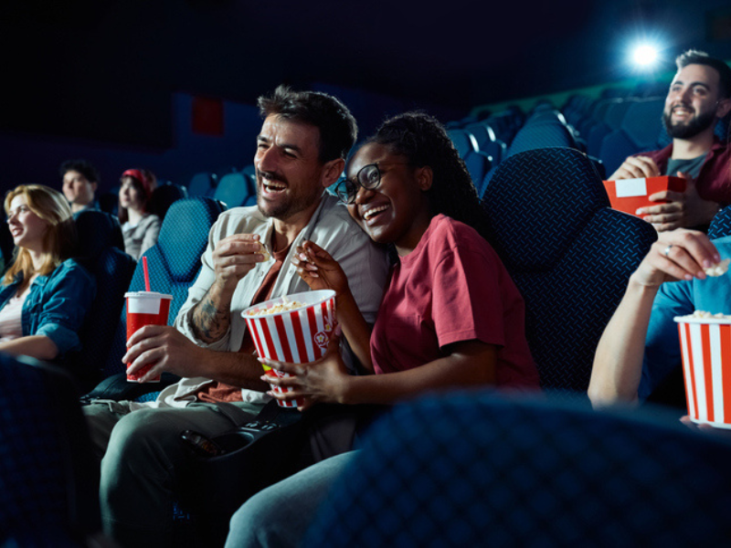 Cheerful moviegoers watching a movie at the cinema