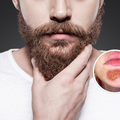 Close up of a man touching his brown beard