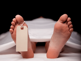 Dead man on morgue table with toe tag on feet