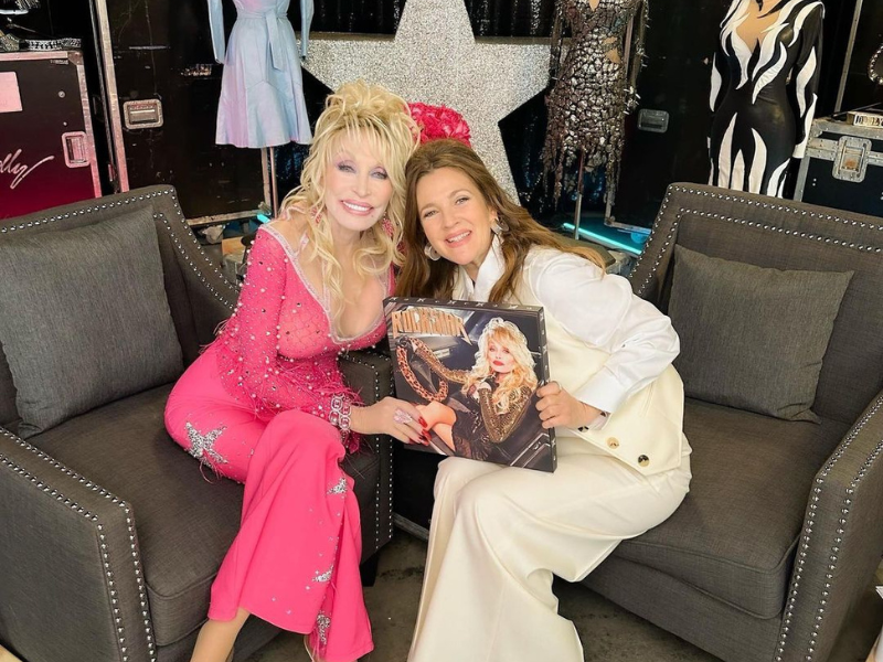 Dolly Parton and Drew Barrymore sitting on a sofa