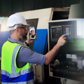 Engineer holding a smartphone while using heavy machinery