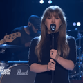 Kelly Clarkson wearing a black dress on stage