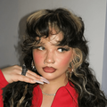 Lola Young curly brown hair and blonde highlights