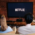 Man and woman sitting on a couch in front of television