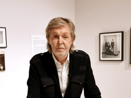 Paul McCartney poses inside a photo exhibition