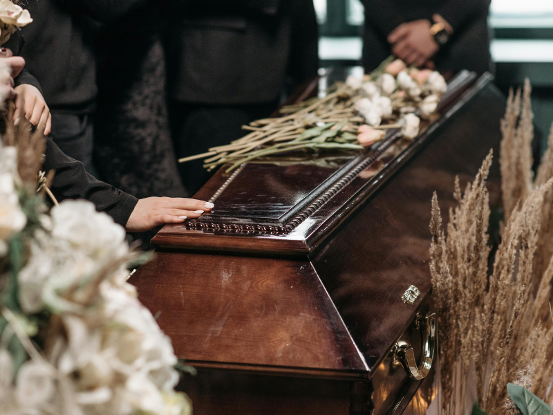 Person holding a wooden coffin