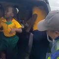 School kids dance inside a taxi while a traffic cop looks on