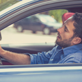 Sleepy and tired fatigued man driving a car in traffic