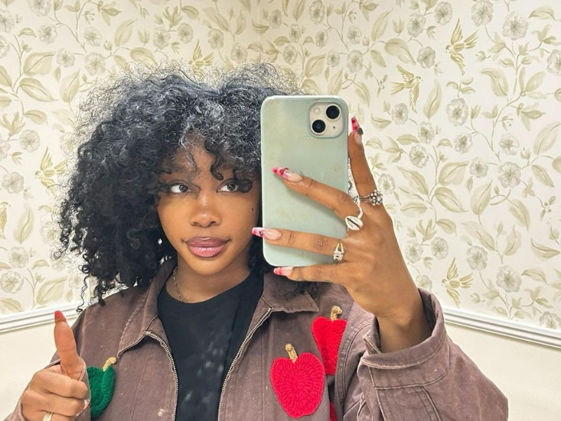 SZA takes a selfie while holding a thumb's up sign