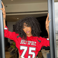 SZA wearing a red football jersey