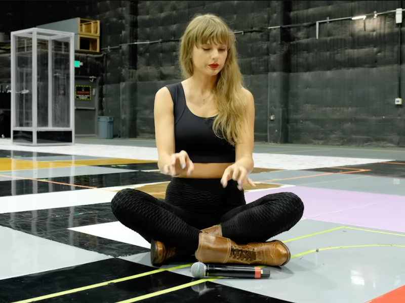 Taylor Swift sitting on a floor