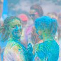 Two happy girls covered in blue colour powder at a colour run