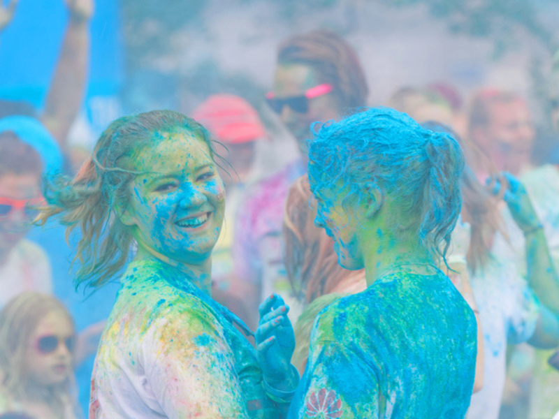 Two happy girls covered in blue colour powder at a colour run