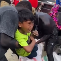 Two men pull a child away from his mother and try to put him inside a sack