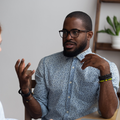 Two people sitting across from another discussing ideas