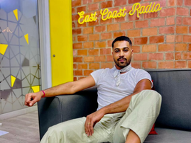 Vic Naidoo sitting at the East Coast Radio house reception