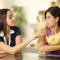 Woman protecting her potato chips from a friend